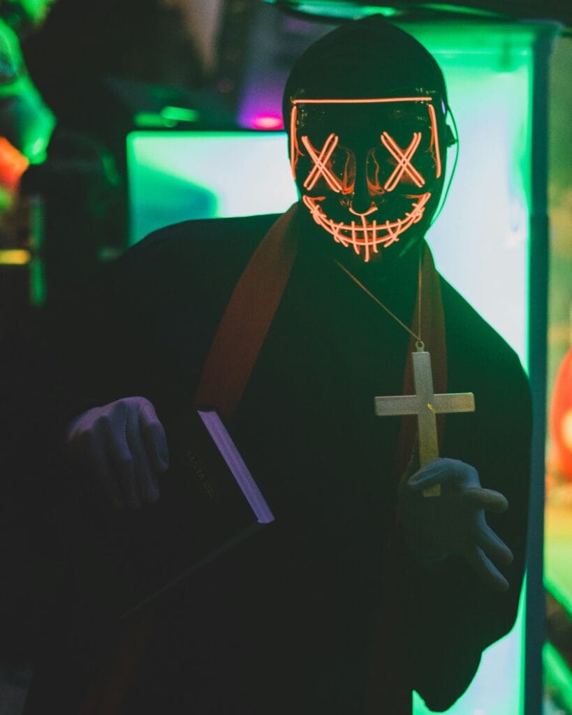 Masked person in neon light – Bartour Berlin mysterious Halloween party theme