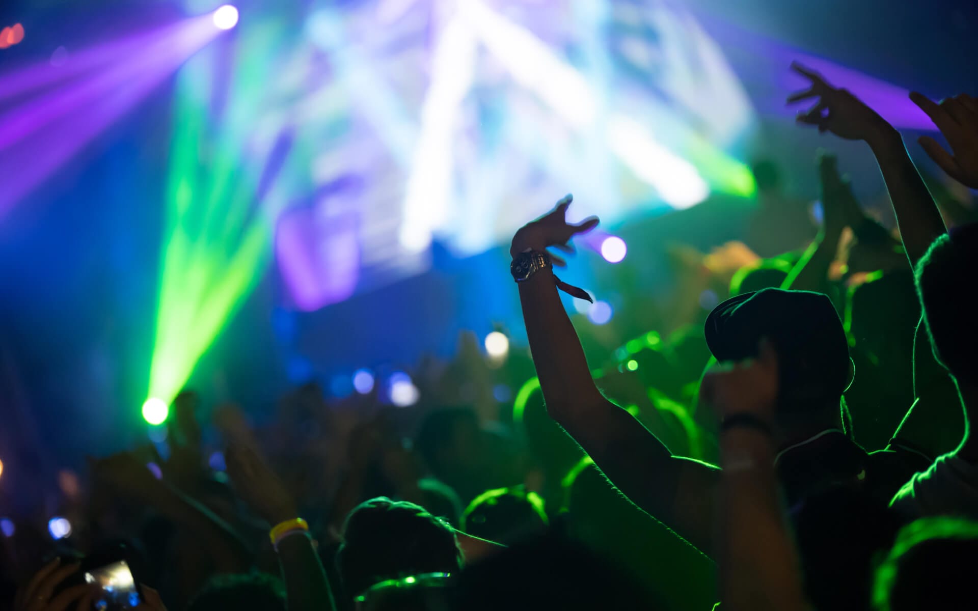 Party crowd at a Berlin nightclub during a pub crawl, dancing under colorful lights